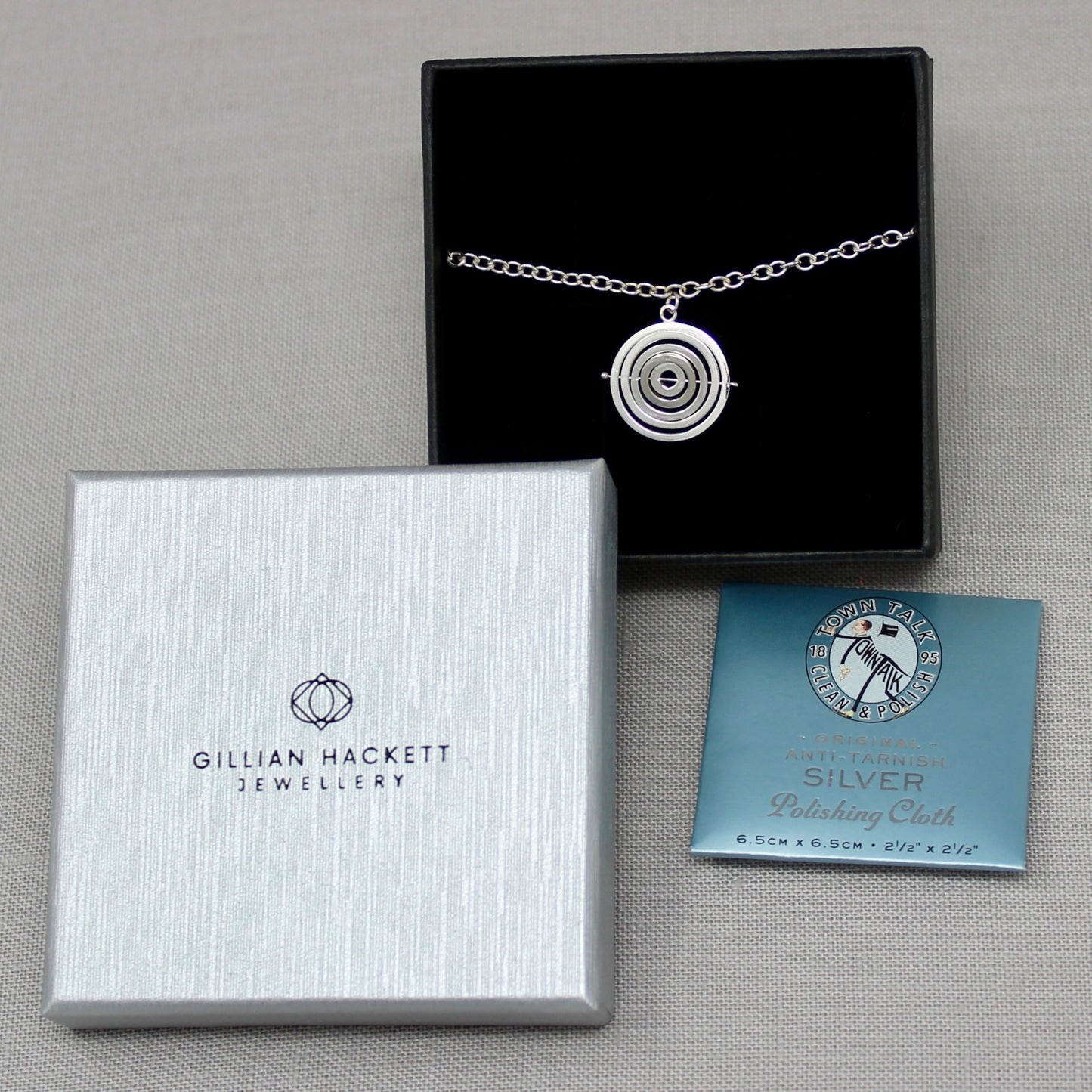 Handmade sterling silver kinetic charm bracelet in Gillian Hackett Jewellery luxury black gift box logo on grey textured lid