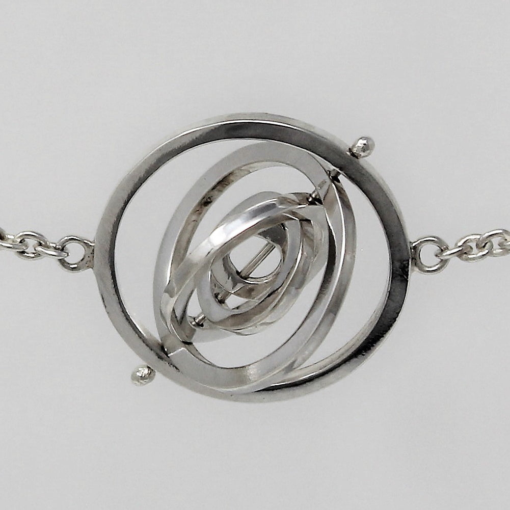5 concentric circle recycled sterling silver square wire rings pivoting on central pin attached to trace chain on each side