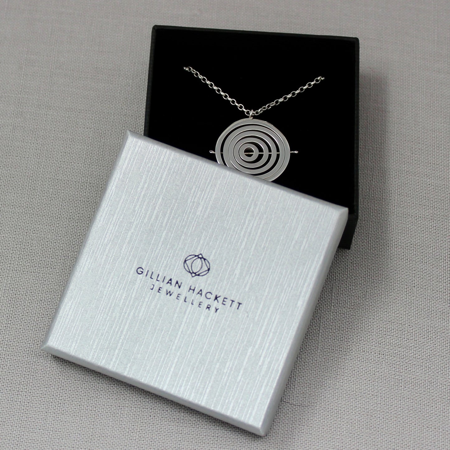 Handcrafted sterling silver kinetic necklace in Gillian Hackett Jewellery luxury black gift box, logo on grey textured lid