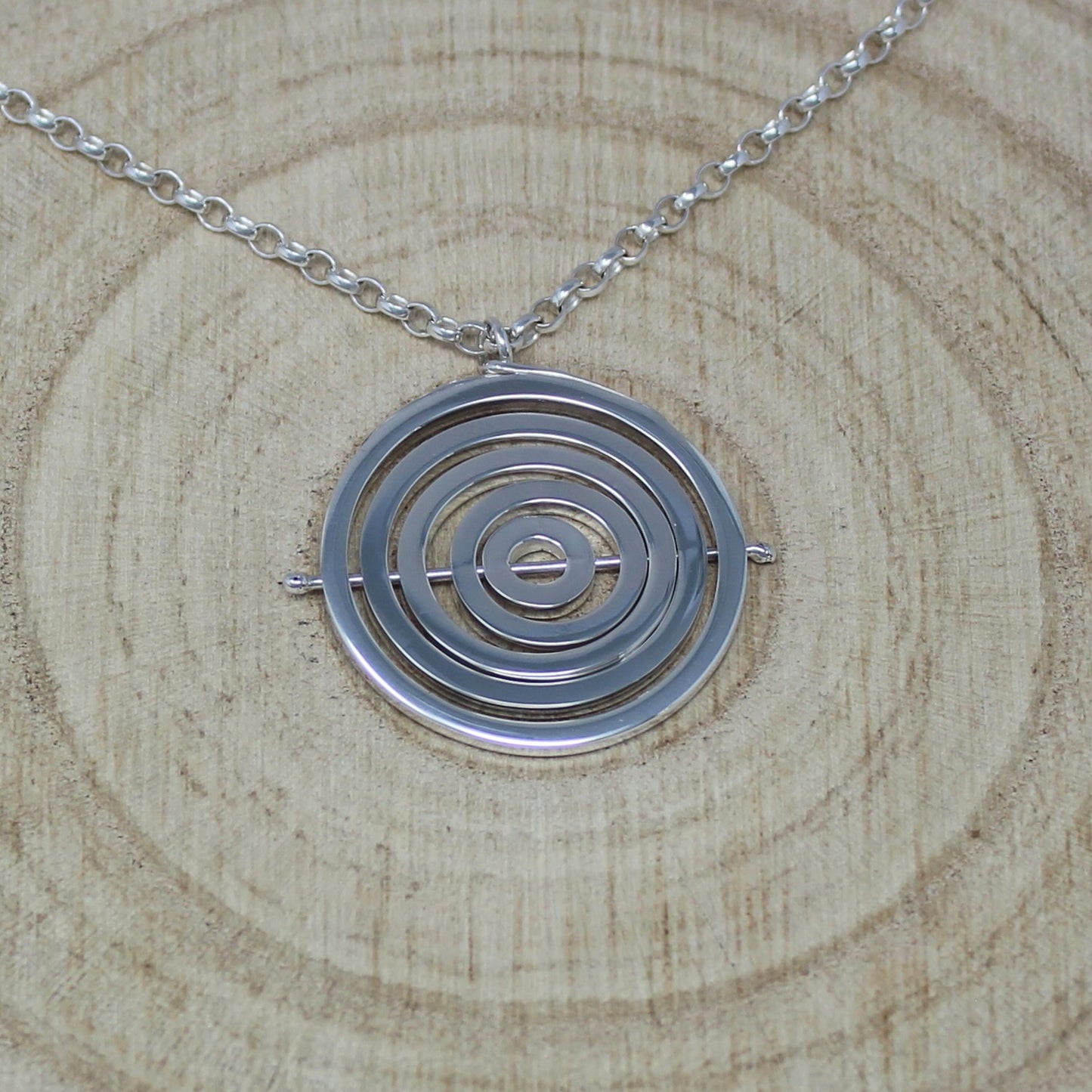 Hallmarked silver kinetic pendant with 5 concentric circle recycled wire rings held by central pin, with chunky belcher chain